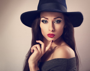 Sexy female model with bright makeup and red lipstick in black h