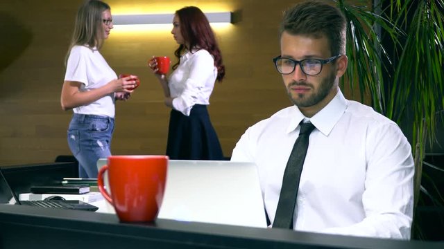 Working in the office as a team. Businessman working at his laptop