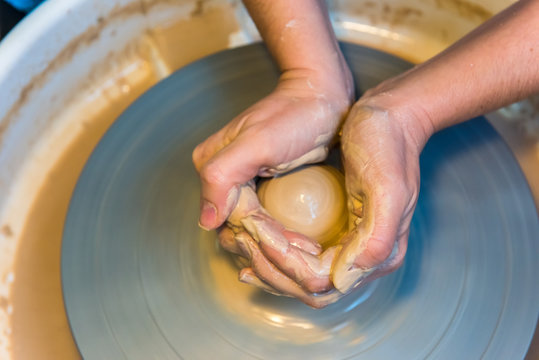 womens hands of a potter creating an earthen jar