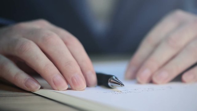 Close up of businesswoman hands writing notes or recommendation letter on business office desk