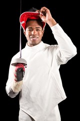 Portrait of swordsman standing with fencing mask and sword