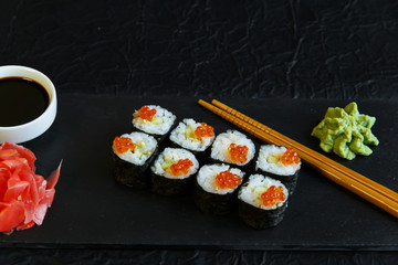  sushi rolls served on stone slate red caviar