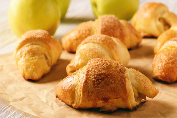Croissants with apple jam on wooden background.