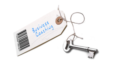 A silver key with a tag attached with a Business Coaching concep