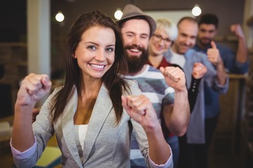Coworkers cheering with clenched fist in creative office