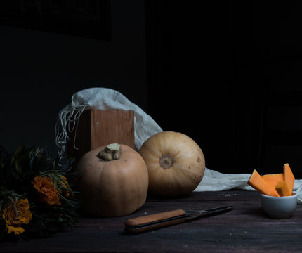 still life, vintage. pumpkin and orange roses on a dark wooden table. art, old paintings
