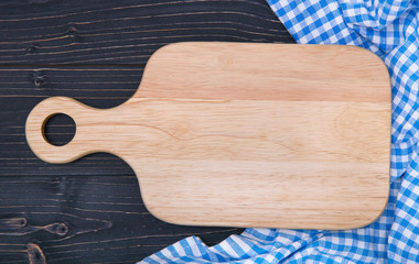 chopping board and towel on a dark wooden background