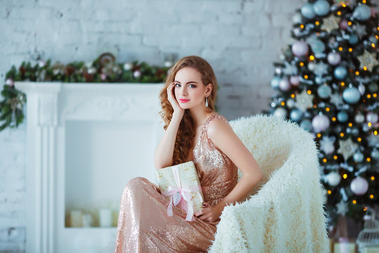 Holidays, celebration and people concept - young woman in elegant dress over christmas interior background. Image with grain