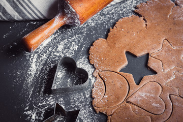 Fototapeta na wymiar Cooking Christmas gingerbread cookies on a dark background