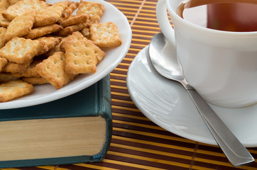 Saucer with a cup of tea and crackers