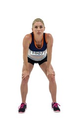 Tired athlete standing with hand on knee