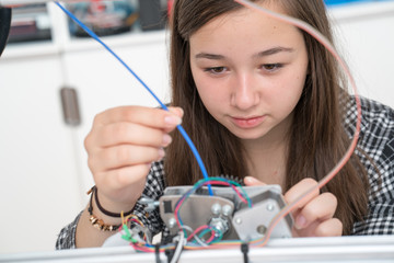girl in robotics class research electronic device