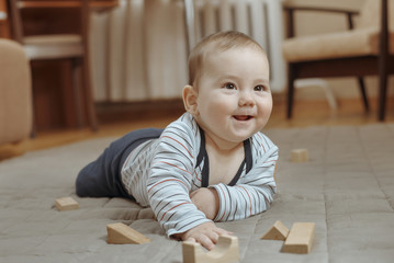 Cute happy little baby boy playing at home