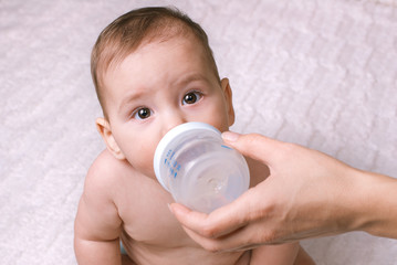 Cute little baby being fed from a bottle