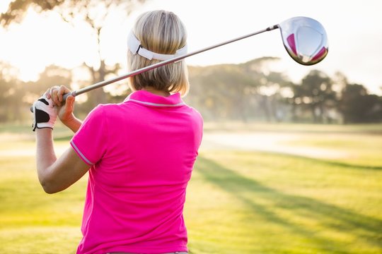 Rear view of sportswoman playing golf