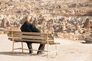 man sitting on a bench and admire the rocky landscape