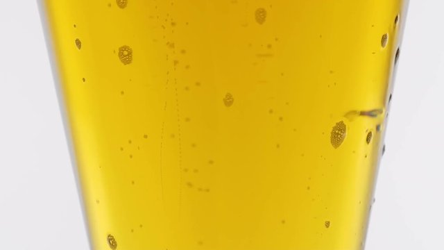 Bubbles of air carbon dioxide in beer float to the top. Slow motion