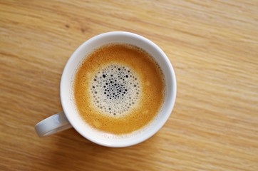Cup of coffee on a wooden background ready for breakfast in the morning.