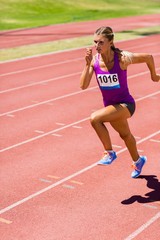 Obraz premium Female athlete running on the racing track