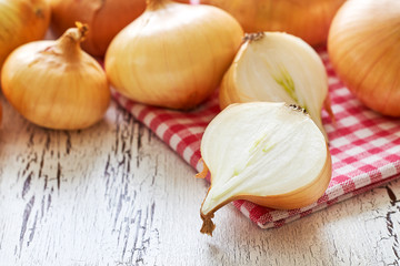 Closeup of onions on white rustic wooden background