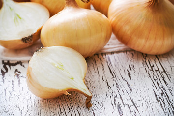 Closeup of onions on white rustic wooden background