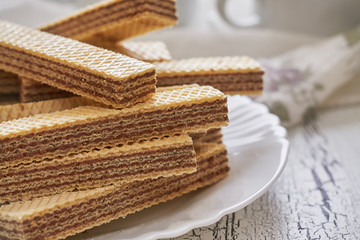 Wafer biscuits with chocolate cream on white rustic wooden background