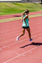 Fototapeta premium Female athlete running on the racing track