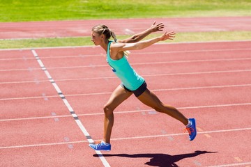Female athlete running on the racing track