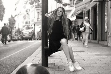 Close-up Fashion woman black and white portrait of young pretty trendy caucasian girl posing at the city in Europe,summer street fashion with lovely sun backlight background