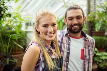 Fototapeta premium Portrait of happy gardeners at greenhouse