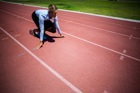 Businesswoman ready to run on running track