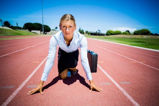 Portrait of businesswoman with briefcase ready to run