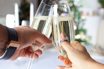 Couple holding glasses of champagne making a toast.