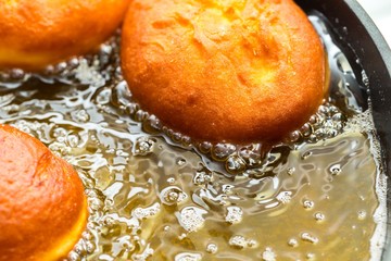 Donuts frying in deep fat - 128792474