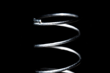 Close metal spring isolated on a black background