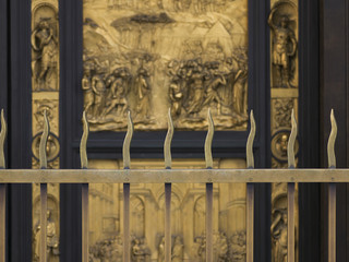 Behind a metal fence a bas relief on a building exterior, Cattedrale di Santa Maria del Fiore, Florence, Italy