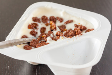 A pot of vanilla yogurt with chocolate crispies on top