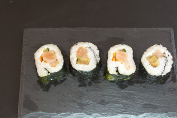 Pieces of sushi on a black stone