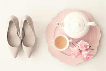 Heel shoes, tea cup, teapot and roses flat lay