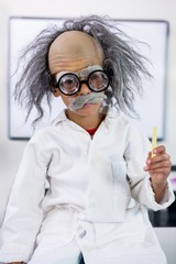Boy dressed as scientist sitting in classroom - obrazy, fototapety, plakaty