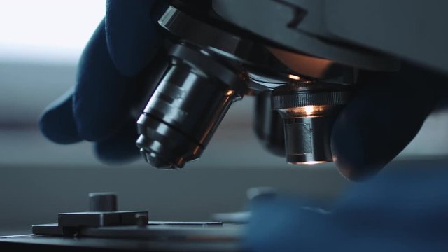 Close up of examining of test sample under the microscope in laboratory.