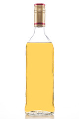 Isolated gold tequila bottle, clear tall alcohol bottle full of yellow liquid on a white background