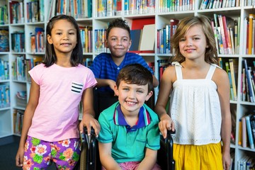 Handicapped boy with friends at library in school