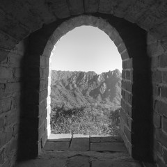 Black & white photo of an arched doorway on the fortification on the Great Wall of China.