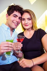 Portrait of happy couple holding cocktail glasses
