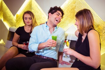 Sad woman sitting by happy couple