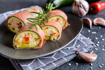 Roasted zucchini stuffed with rice, cheese, pepper and wrapped in Prosciutto slices