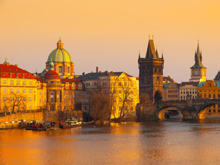 Naklejka na ściany i meble Prague Evening. Towers of Old Town and Charles Bridge over Vltava River illuminated by orange sunset. UNESCO World Heritage Site. Prague, capital city of Czech Republic, Europe