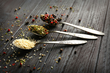 Assortment of spices in spoons on wooden background