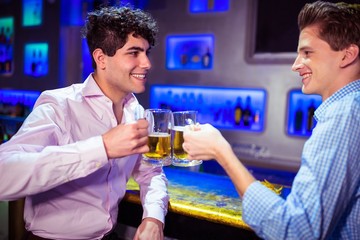 Happy friends toasting beer